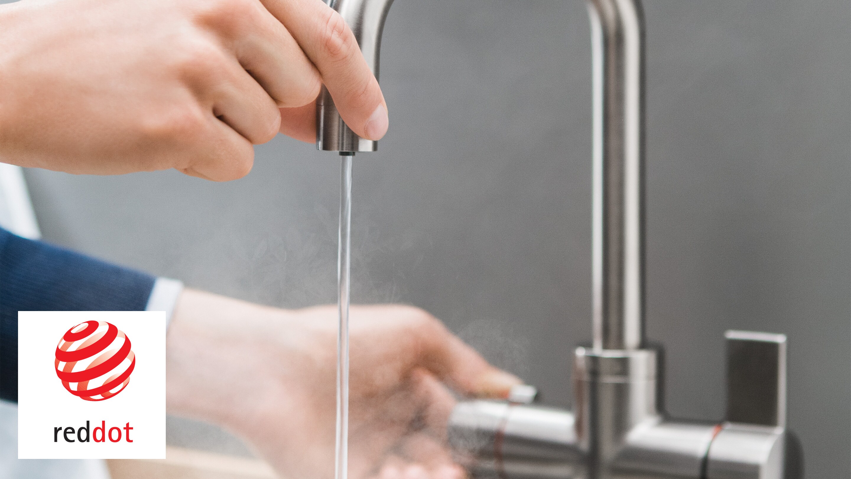Ein Mann, der den Auslauf sicher berühren kann, während kochend heißes Wasser austritt