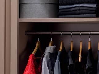 Frisch gewaschene Kleidungsstücke in einem Schrank aufgehängt