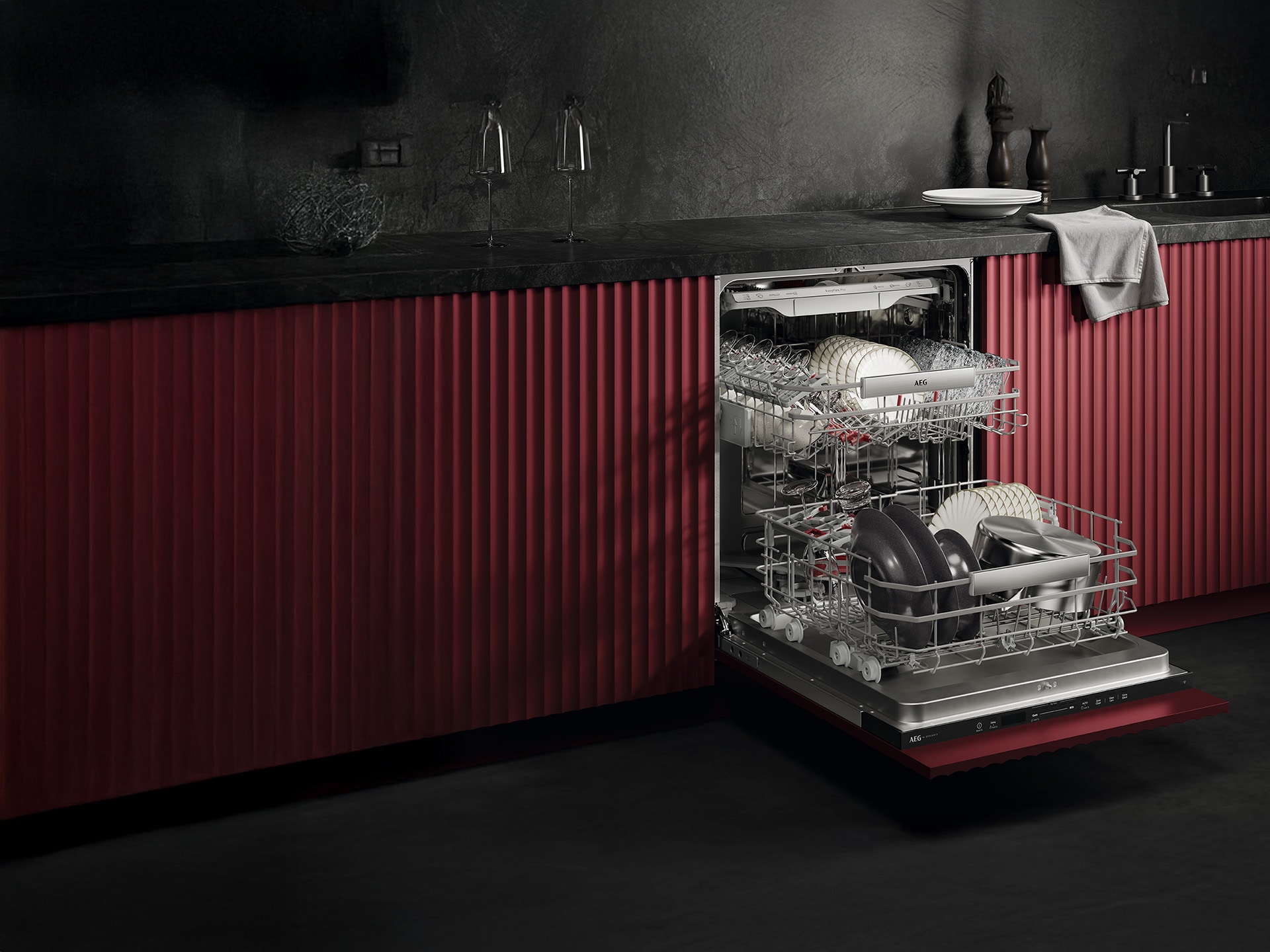 Offene Spülmaschine mit Geschirr in moderner Küche mit dunkelroten Fronten.