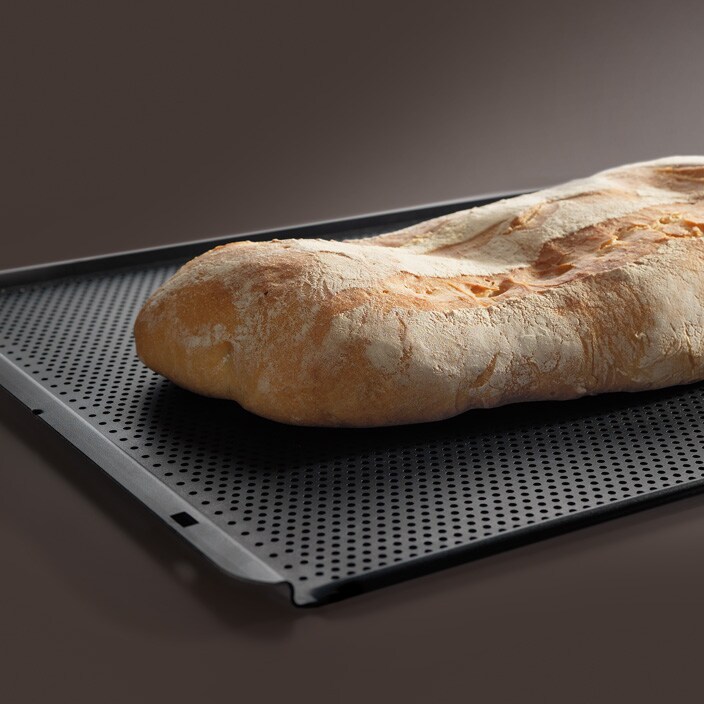 Ein goldener Brotlaib wird auf dem AEG Maxiklasse Backblech gebacken. 