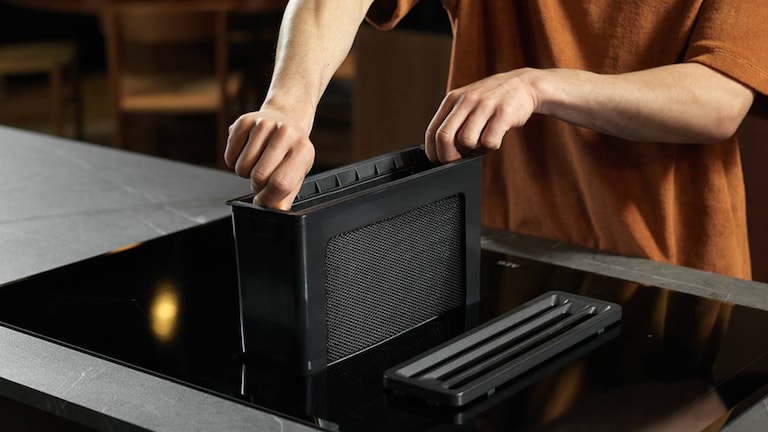 Hand inserting Cooker Hood filter