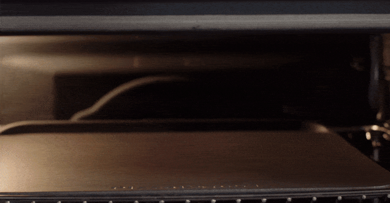 Video of a person making pizza using oven