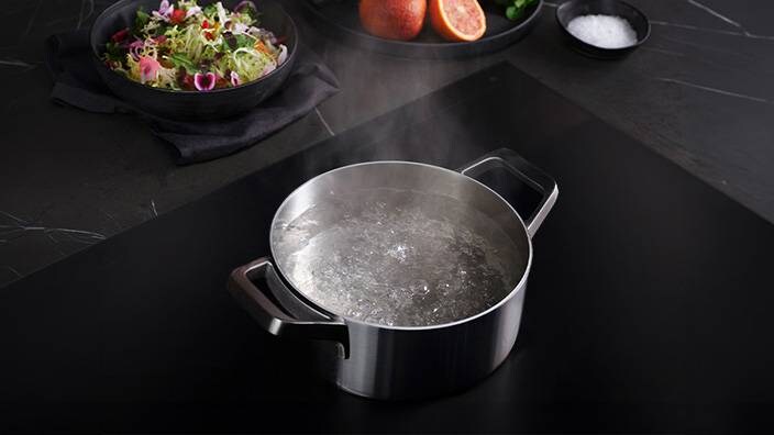 Ein Topf mit kochendem Wasser auf einem Induktionskochfeld