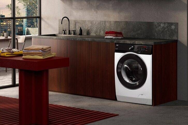 Eine Waschmaschine steht in einer Küchenzeile